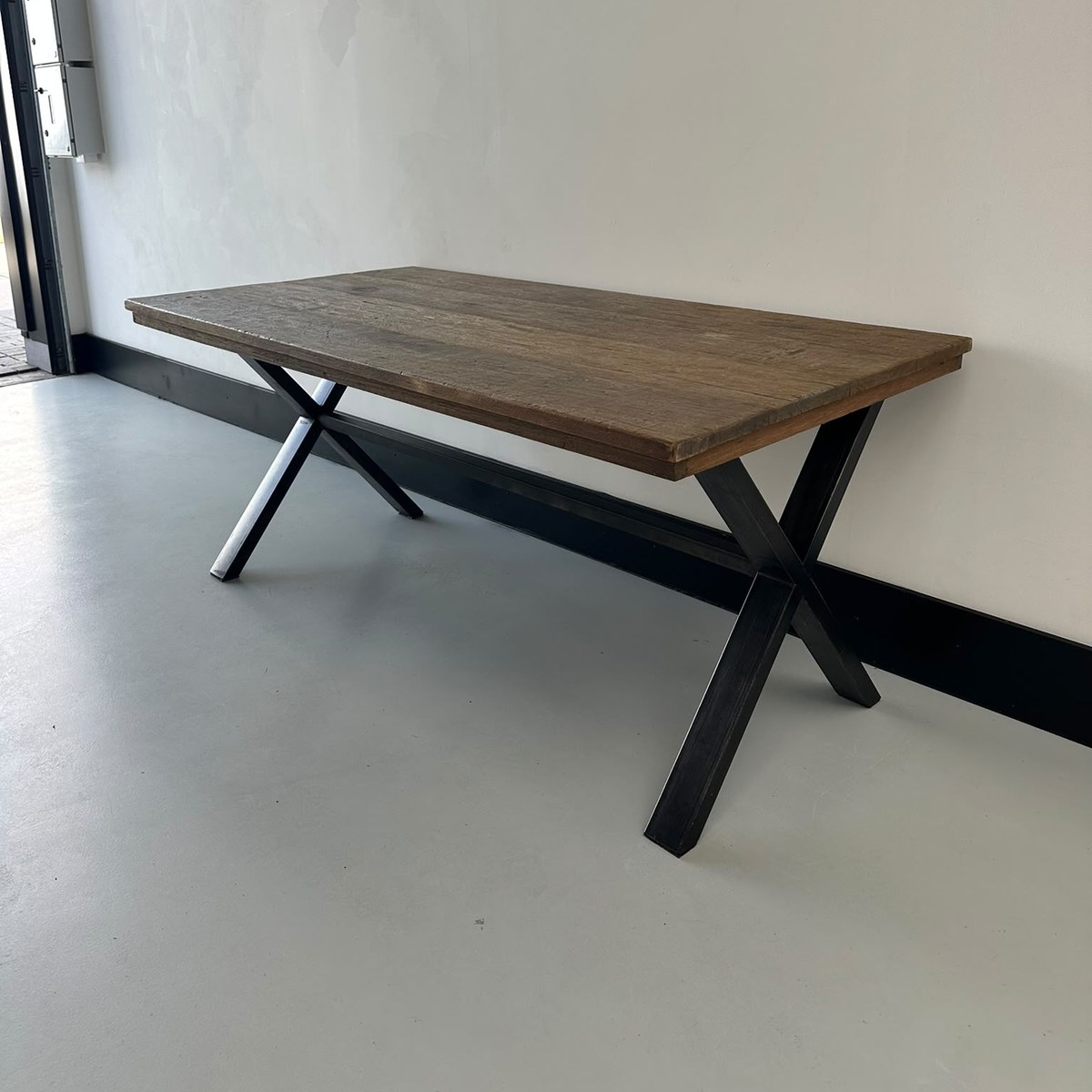 Robuuste eettafel van massief hout met zwart X-onderstel